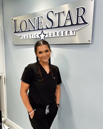 Alexandra Romo, Aesthetician and Senior Laser Technician in black scrubs in front of Lone Star Plastic Surgery sign.